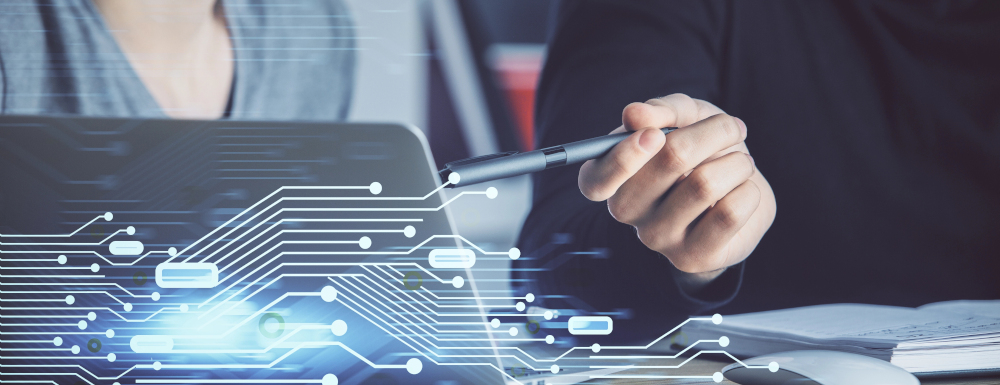 persona che indica lo schermo di un laptop, con fantasia come circuiti stampati